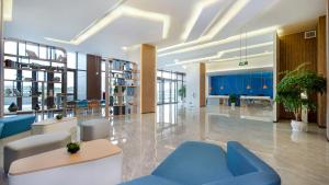 a lobby with a blue couch and tables and chairs at Holiday Inn Express Chengdu Tianfu Airport Zone, an IHG Hotel in Jianyang