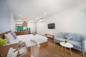 峴港的住宿－Samatha Apartment & Hotel，客厅配有床、沙发和桌子