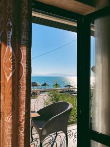 una ventana con vistas al océano, mesa y sillas en Инжу Алаколь en Qabanbay