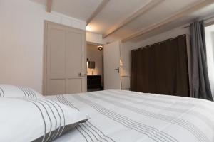 ein großes weißes Bett in einem Zimmer mit Fenster in der Unterkunft la petite maison du Portrieux in Saint-Quay-Portrieux