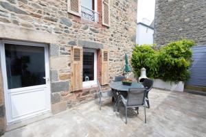 a patio with a table and chairs in front of a building at la petite maison du Portrieux in Saint-Quay-Portrieux