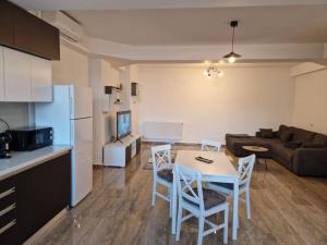 eine Küche und ein Wohnzimmer mit einem Tisch und Stühlen in der Unterkunft Danube Double in Brăila