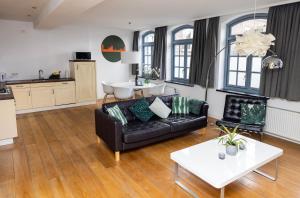 a living room with a black couch and a table at Appartement La Charrette in Tilburg