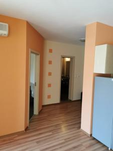 um quarto vazio com paredes cor-de-laranja e pisos em madeira em Private Apartment in Golden Sands - Aquamarine Odessos em Golden Sands