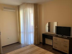 um quarto com uma televisão numa cómoda com um espelho em Private Apartment in Golden Sands - Aquamarine Odessos em Golden Sands