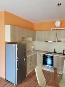 uma cozinha com um frigorífico e uma cadeira. em Private Apartment in Golden Sands - Aquamarine Odessos em Golden Sands