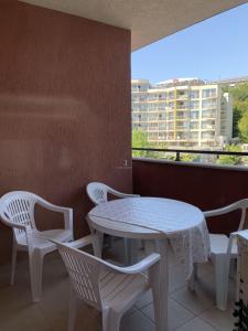 uma mesa branca e cadeiras numa varanda com uma janela em Private Apartment in Golden Sands - Aquamarine Odessos em Golden Sands