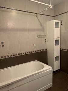 uma casa de banho com uma banheira branca e um frigorífico branco em Private Apartment in Golden Sands - Aquamarine Odessos em Golden Sands