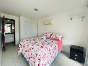 Cette petite chambre comprend un lit avec un couvre-lit rose. dans l'établissement Flat Apartamento, 50m da praia, à João Pessoa