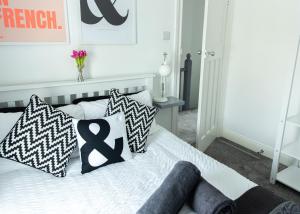 um quarto com uma cama com almofadas pretas e brancas em Entire family home , large rear garden and free parking em Belfast