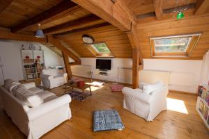 a living room with white furniture and wooden ceilings at Maison Suchard, tradition & elegance in the Jura in Couvet