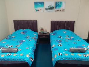 dwa łóżka siedzące obok siebie w sypialni w obiekcie Merit Mansion w mieście Bangkok