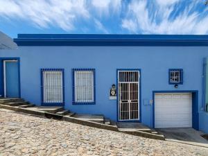 un edificio azul con tres puertas y una entrada en Trendy home in heart of City Heritage, Mtn Views en Ciudad del Cabo