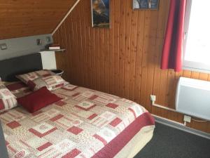 um quarto com uma cama com uma colcha em La Récré em Laye