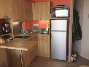 a kitchen with a refrigerator and a microwave on top of it at La Récré in Laye