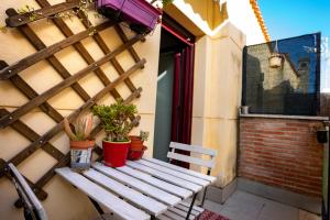 a wooden bench sitting on a balcony with potted plants at LOFT BETANIA in Cáceres