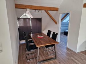 ein Esszimmer mit einem Holztisch und Stühlen in der Unterkunft Dachstudio Eggingen in Eggingen + 2 Fotos