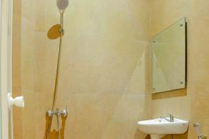 La salle de bains est pourvue d'une douche et d'un lavabo. dans l'établissement HP Residence Mitra RedDoorz near Alun Alun Kediri, à Kediri