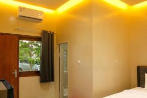 諫義里的住宿－HP Residence Mitra RedDoorz near Alun Alun Kediri，天花板上设有黄色灯的卧室
