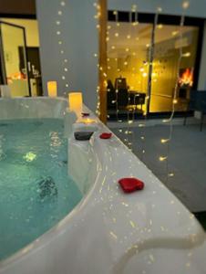 a bath tub filled with water with a red object at Le GREEN'SPA - DIJON - SPA-jardin-parking privé in Longvic