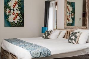 Un dormitorio con una cama grande con sábanas y almohadas blancas. en Relax Bali Villas, en Legian