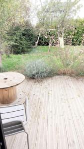 a table and a chair on a wooden deck at Gite lumineux de 45m2 en cœur de ville in Saint-Avertin