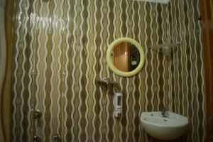 a bathroom with a sink and a mirror on the wall at Hotel Shakuntla Palace in Gaya