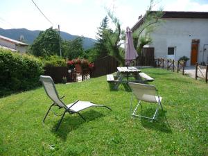 twee stoelen en een tafel en een paraplu in de tuin bij Le Tamaris in Die