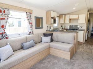 a living room with a couch in a caravan at 3 Bed New Lodge - 7 Lakes Country Park DN17 in Scunthorpe
