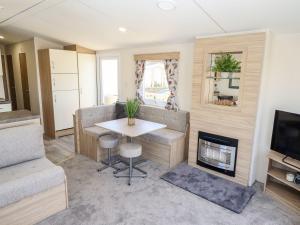 a living room with a table and a fireplace at 3 Bed New Lodge Sleeps 4 Pets Welcome in Scunthorpe +8 photos