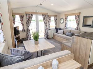 a living room with a couch and a table at 3 Bed New Lodge - 7 Lakes Country Park DN17 in Scunthorpe
