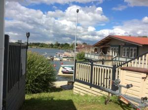a house with a fence next to a body of water at 3 Bed New Lodge - 7 Lakes Country Park DN17 in Scunthorpe