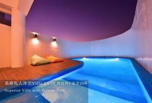 a pool in a room with a bed next to it at 白色海芋Villa in Nanwan