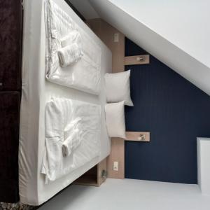 Habitación con escaleras, almohadas y mantas blancas en Die Remise Copenhagen RE-16 en Stolpe auf Usedom