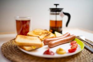 a plate with two hot dogs and toast and a drink at Yellow Hostel 24h - śniadanie i obiad gratis - Free Parking in Katowice