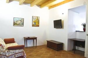 ein Wohnzimmer mit einem Sofa und einem TV in der Unterkunft Tra Gli Olivi E La Riviera Del Conero in Numana