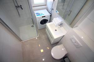 a bathroom with a toilet and a washing machine at Apartments Ane 1 Tisno in Tisno