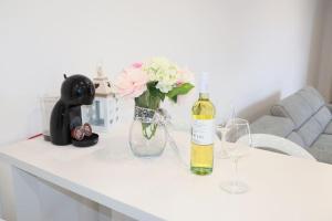 a table with a bottle of wine and a vase with flowers at Apartments Ane 1 Tisno in Tisno +2 photos