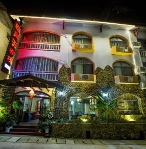 un edificio de noche con luces en Zhangjiajie April Hostel en Zhangjiajie