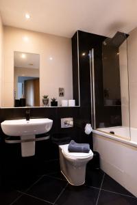 a bathroom with a sink and a toilet and a tub at Apartment @ I Quarter in Sheffield