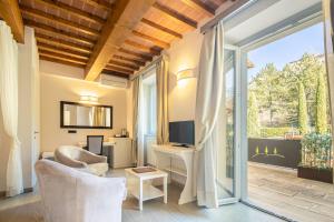 a living room with a tv and a sliding glass door at Beautiful villa with private lawn, pool and luxury SPA by VacaVilla in Poppi
