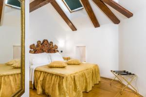 a bedroom with a bed with a gold bedspread and a mirror at Charles Bridge Palace in Prague