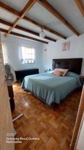 sypialnia z dużym łóżkiem i drewnianą podłogą w obiekcie Cabaña VILLA ANGÉLICA-LUNAHUANA w mieście Lunahuaná