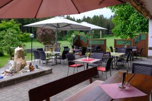 ein Restaurant mit Tischen, Stühlen und einem Sonnenschirm in der Unterkunft Wirt in der Spöck in Neukirchen an der Vöckla