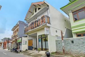 un edificio blanco con balcón en una calle en OYO Life 92312 A+ Cozy Rooms Syariah, en Kediri