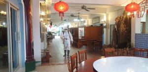 a person walking down a hallway in a restaurant at GG Sweet Home in Mae Sot