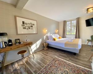 a hotel room with a bed and a desk and a bed at Domaine Utah Beach - Le Grand Hard in Sainte-Marie-du-Mont