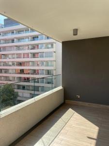 an empty room with a balcony with a large building at 24 metros Clínica las Condes in Santiago