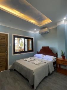 a bedroom with a large bed and a window at Siquijor Plage Inn in Siquijor