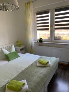 a bedroom with a large bed with green towels on it at Helenes Ferienwohnung auf dem Bauernhof - Lausitzer Seenland in Laubusch